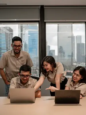 Team collaborating on laptops in a modern office with city views